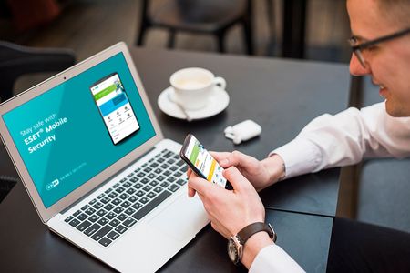 A laptop in a coffee shop showing the ESET mobile security software