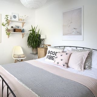 bedroom with white wall and cushions on bed