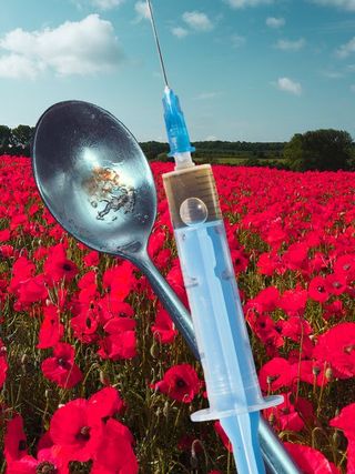 Syringe, spoon and poppy field