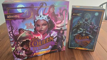 Queen by Midnight box with expansion, laid out on a wooden table