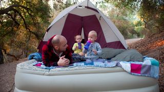 Man and his two young children on an air mattress