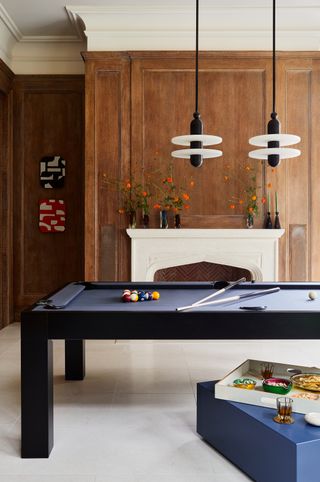 games room with two modern pendant lights over a pool table