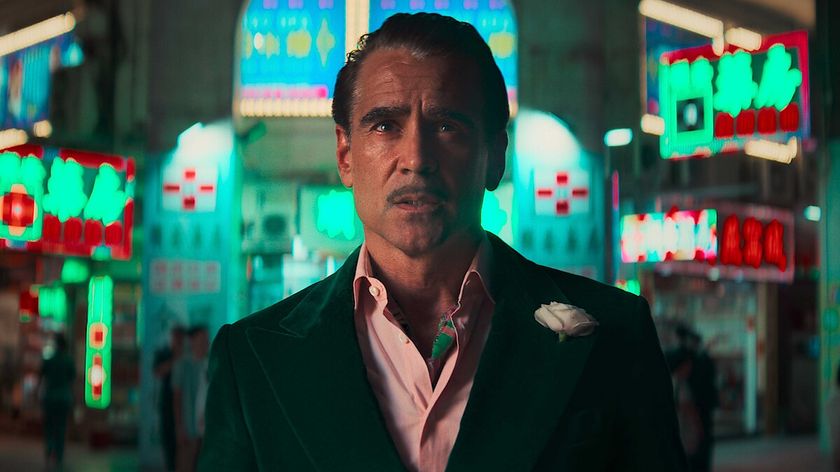 Colin Farrell's Lord Doyle standing in a city at night surrounded by neon lights in Ballad of a Small Player