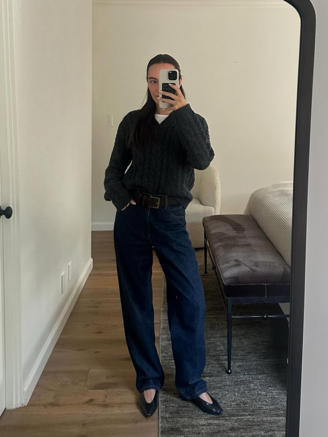 Liv Perez in a v-neck sweater and dark wash straight-leg jeans.