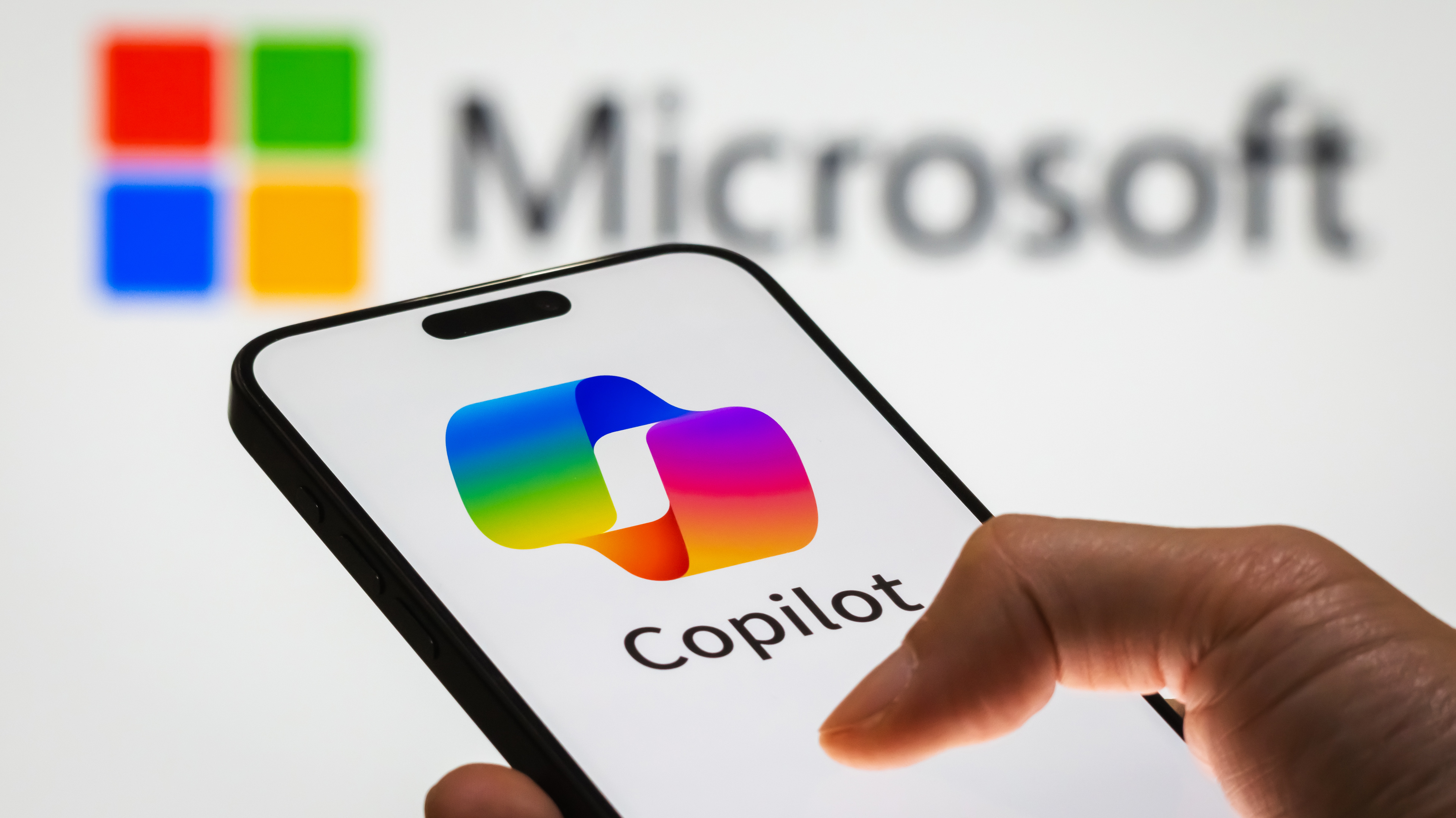 CHONGQING, CHINA - DECEMBER 29: In this photo illustration, a person holds a smartphone displaying the logo of Microsoft Copilot, an AI-powered productivity tool, with the Microsoft logo visible in the background, representing the integration of artificial intelligence into workplace solutions, on December 29, 2024 in Chongqing, China. Artificial Intelligence (AI) has become a cornerstone of Chinaâ€™s strategic ambitions, with the government aiming to establish the country as a global leader in AI by 2030. (Photo illustration by Cheng Xin/Getty Images)