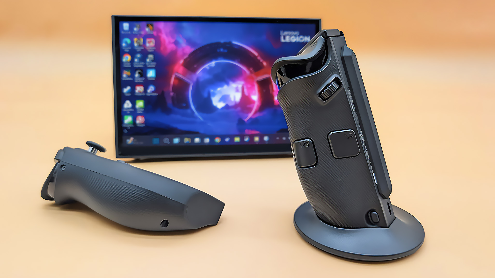 The Lenovo Legion Go 2 right controller in its FPS mode base with the let controller lying down. The Legion Go 2 is propped up on its kickstand behind them.