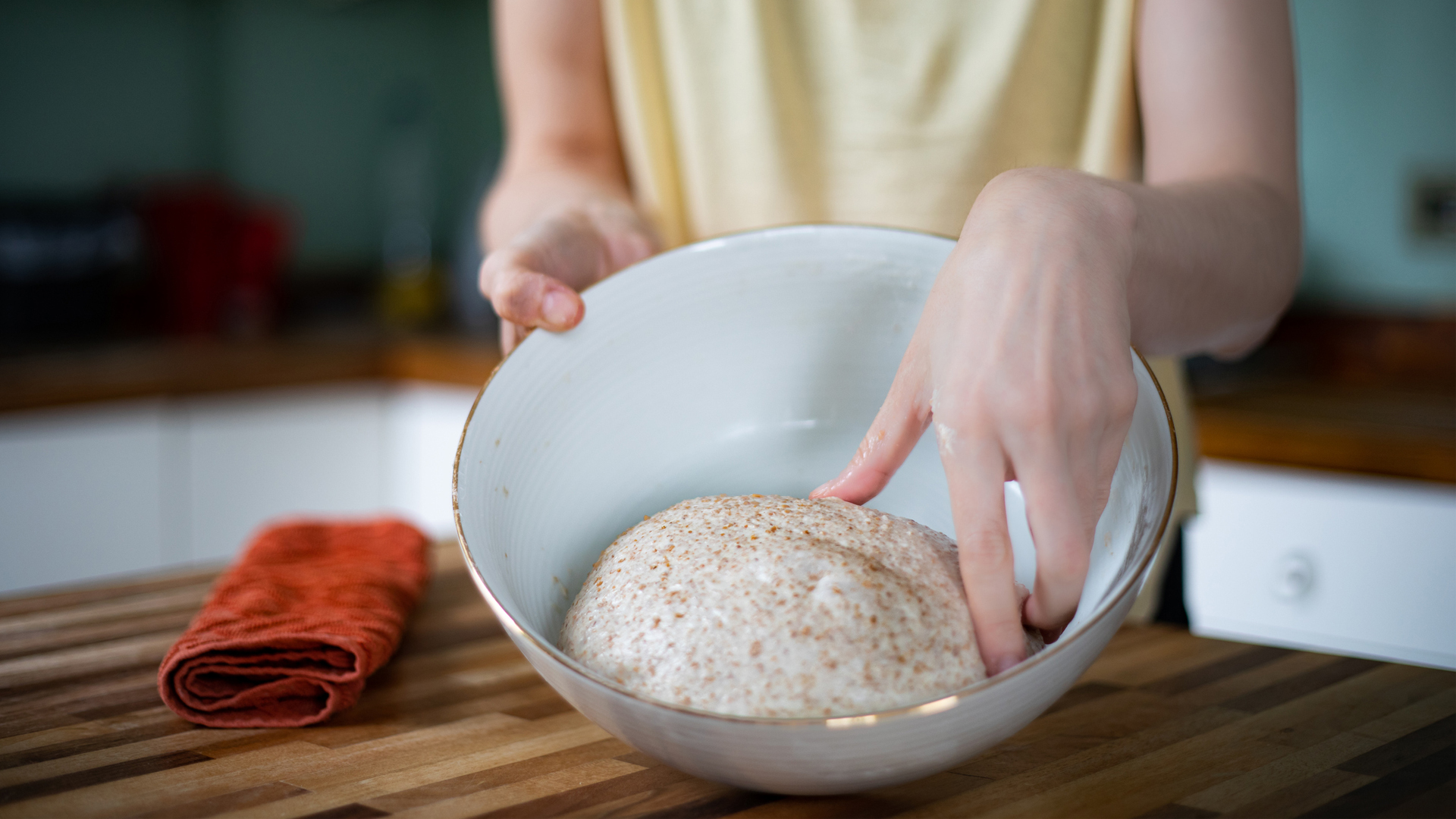 mujer haciendo masa de trigo integral en su cocina