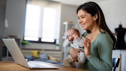 Happy young mother with baby having video call