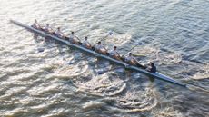 People in long canoe oaring 