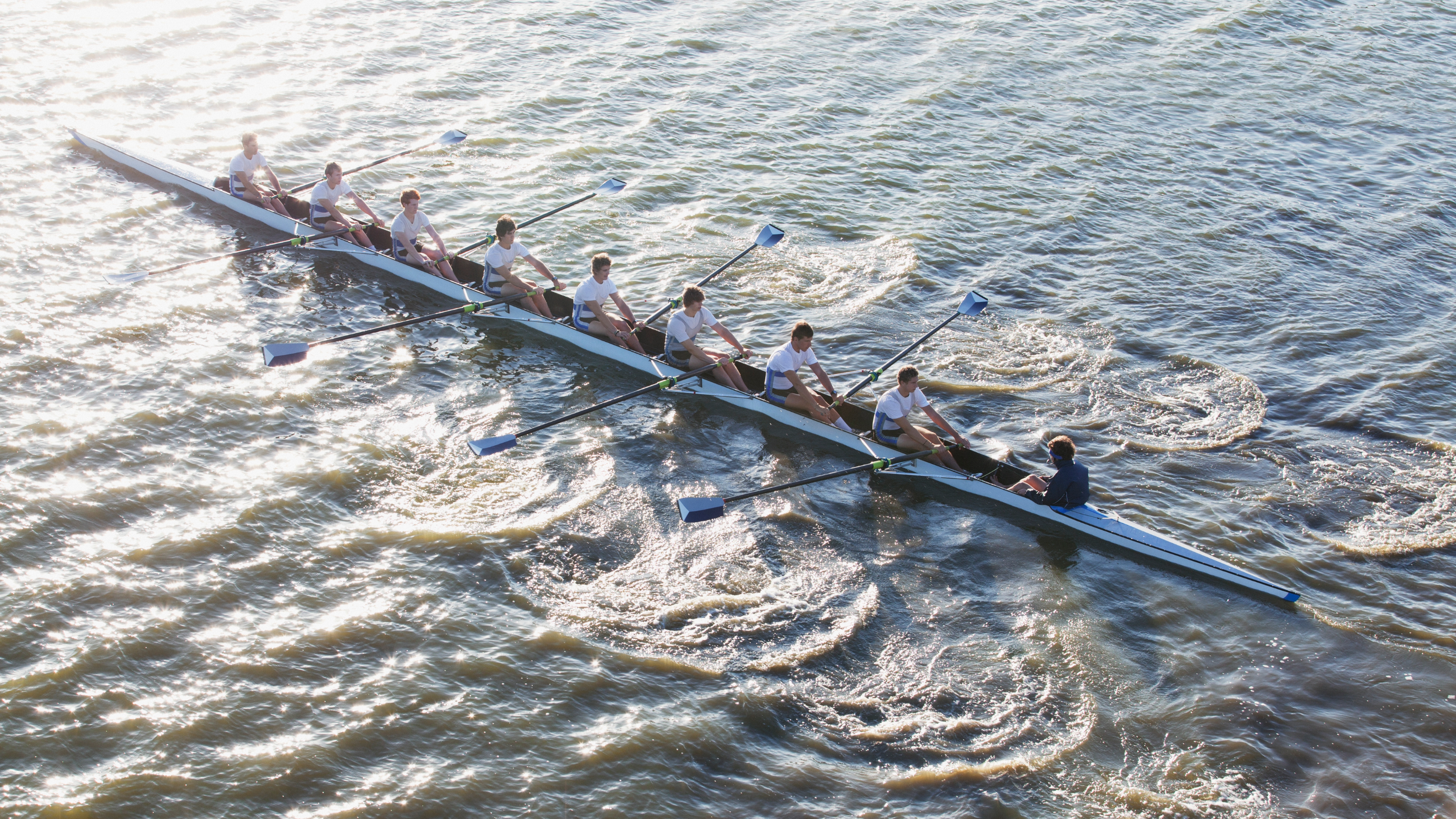 People in long canoe oaring 