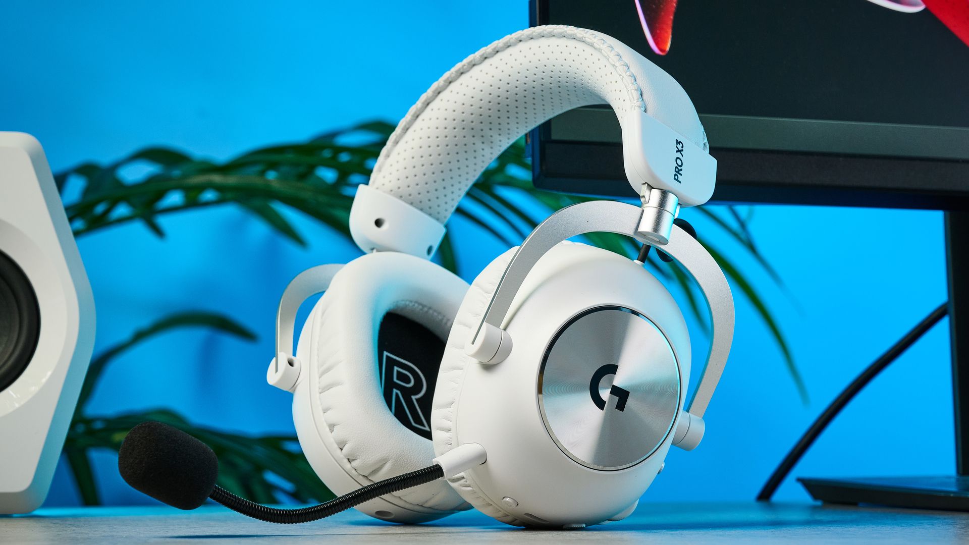 The Logitech G Pro X3 Lightspeed headset in white, on a stone surface.