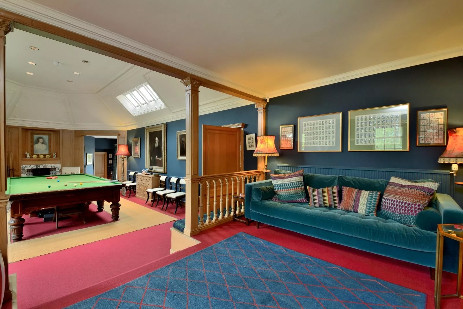 A snooker room with blue walls and lots of sofas