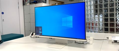 Samsung M8 Smart Monitor on a desk in a busy office environment