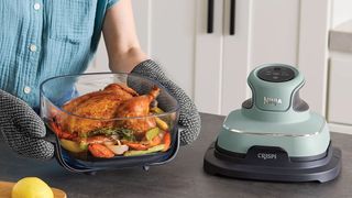 Person cooking roast chicken and vegetables using Ninja Crispi air fryer