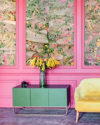 A living room with period panels painted in bright pink with panels framing marbled papers by Nat Maks