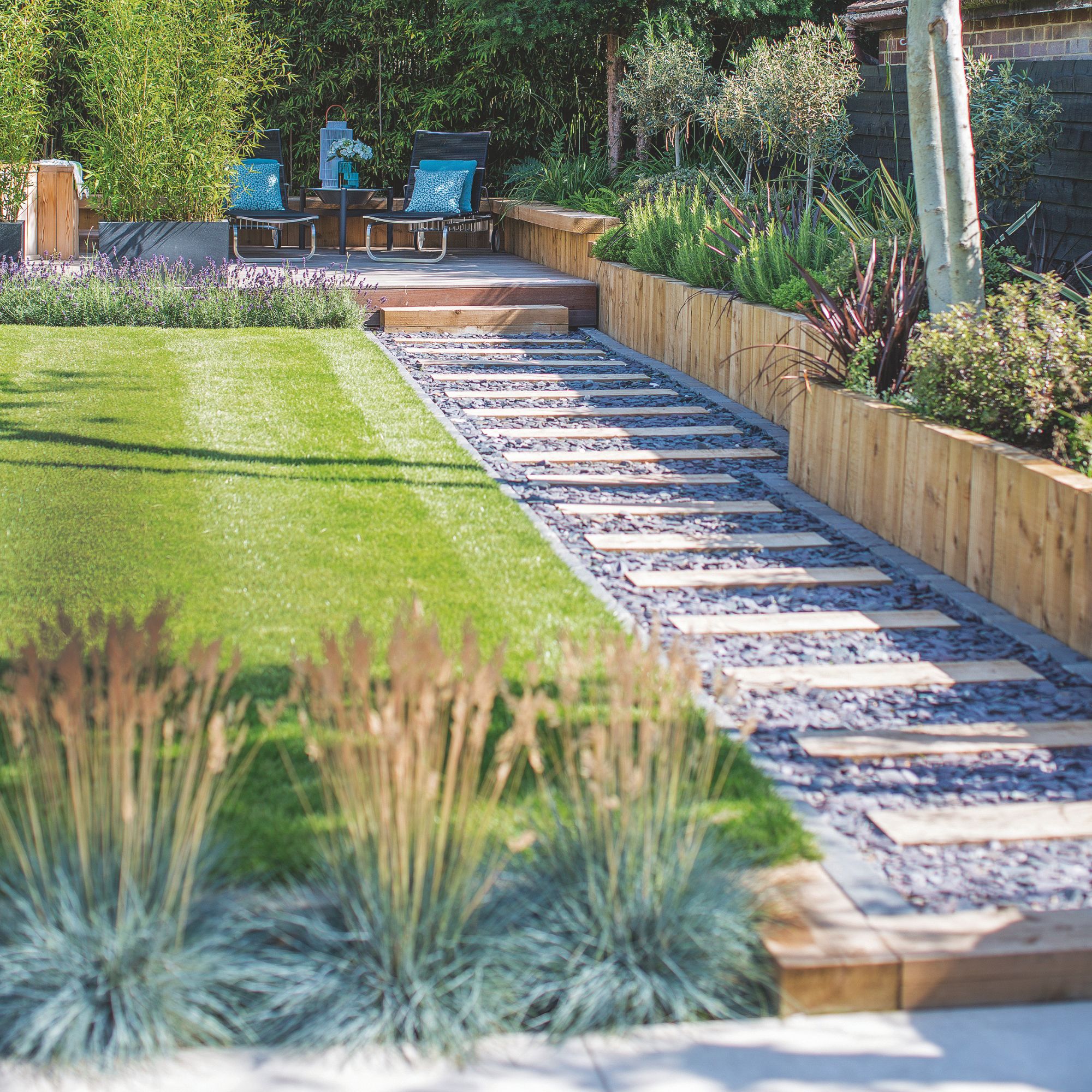 Garden with a flat lawn and a stepping stone path towards a seating area towards the back of the garden