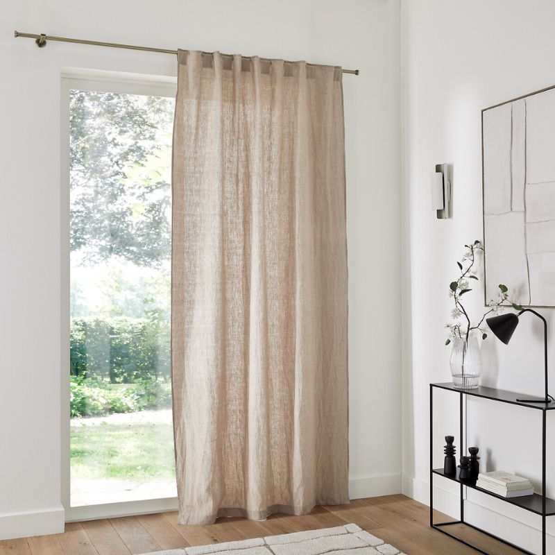 white room with door with beige linen curtain