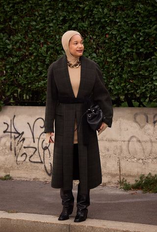 Milan Fashion Week spring 2025 street style photo of a woman wearing the over the knee boot trend