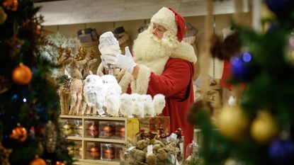 Father Christmas browses the decorations during a promotional event to launch the Selfridges Christmas Shop in their flagship store in central London on August 3, 2015. With 142 shopping days