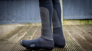 A image of a cyclist wearing Spatz Pro Stealth overshoes on wooden decking 