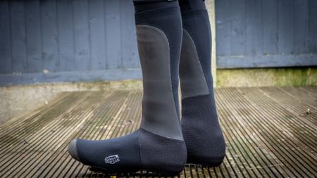 A image of a cyclist wearing Spatz Pro Stealth overshoes on wooden decking 