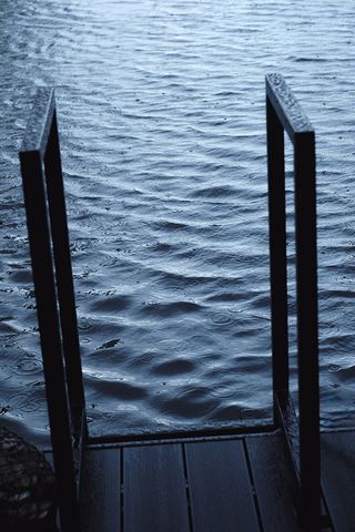 wyld sauna with blackened wood exterior floating on water