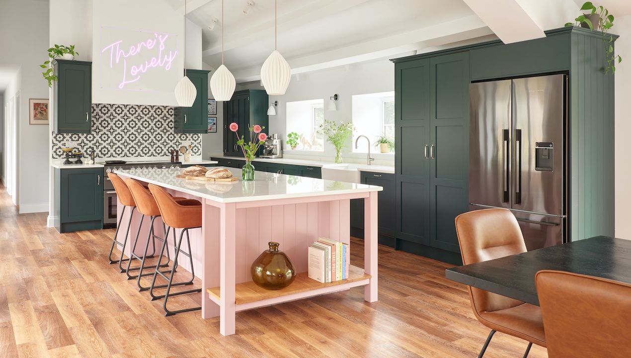 pink and green shaker kitchen with neon sign above range cooker and wooden floors