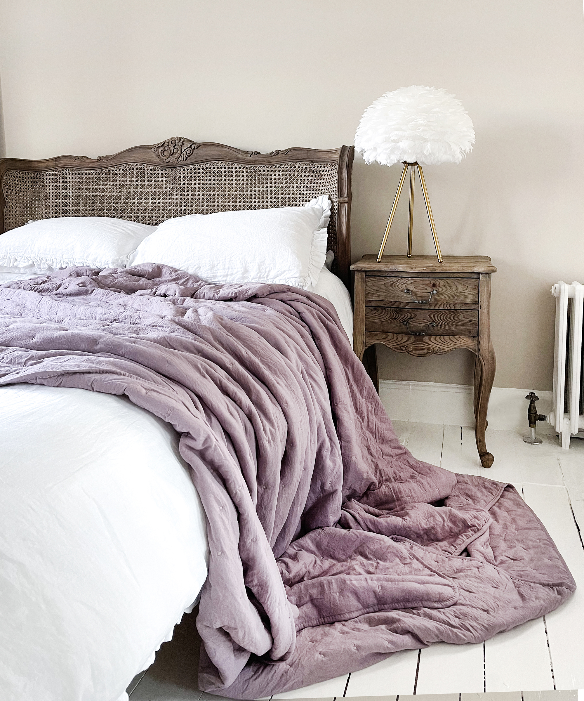 Feathered lampshade by The French Bedroom Co in rustic bedroom scheme with lilac throw