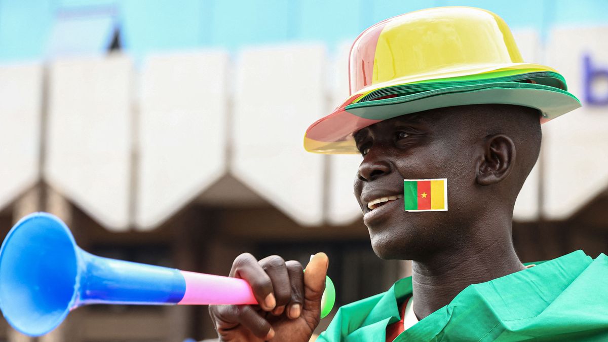 A vendor selling Cameroon football attire poses for a portrait in Yaounde