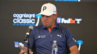 Gary Woodland looks down at the PGA Tour Courage Award in his right hand during his Cognizant Classic press conference