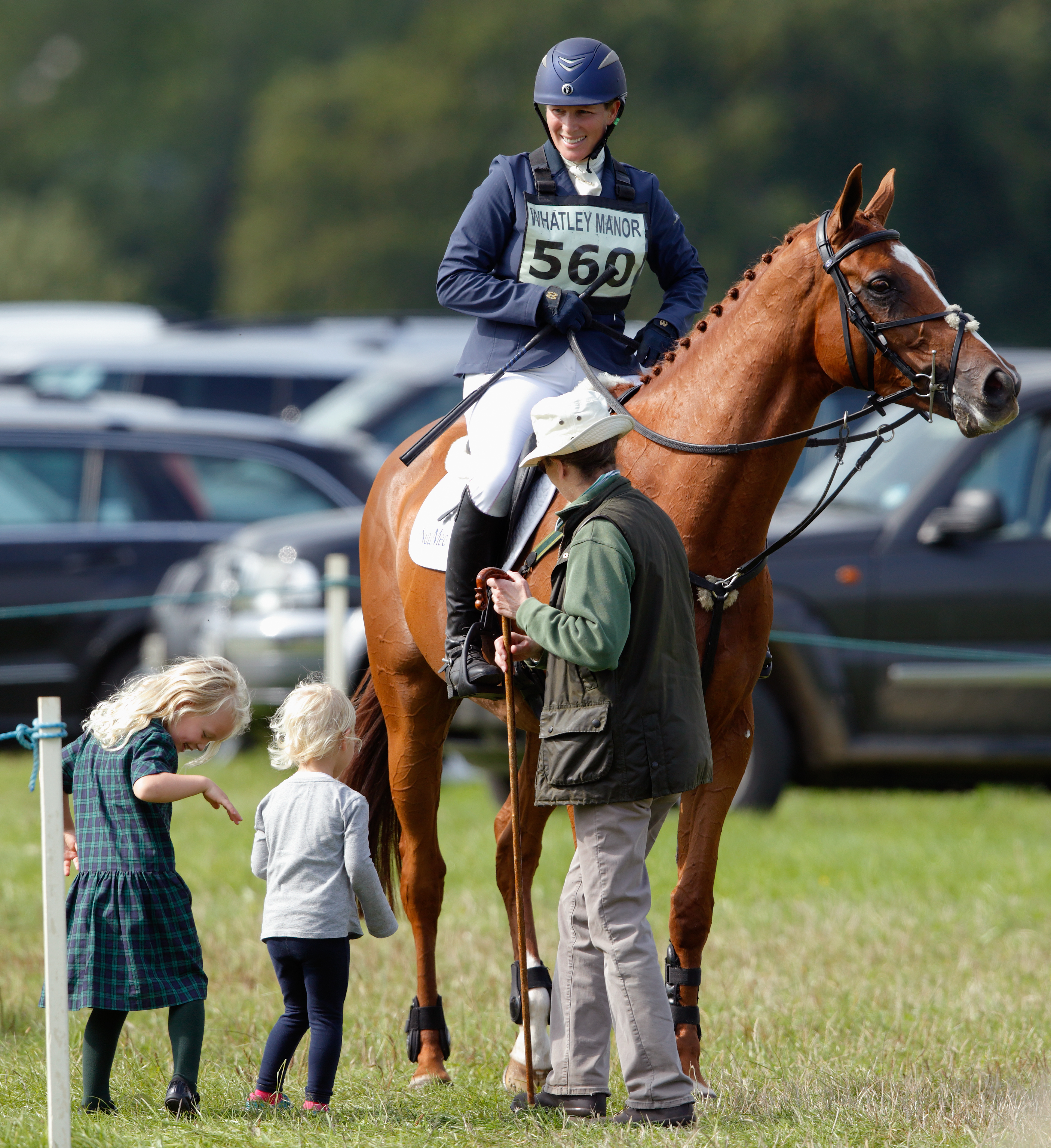 Zara Tindall on a horse looking down at her kids and Princess Anne
