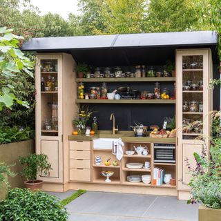 outdoor kitchen with cream colour cabinet and plants