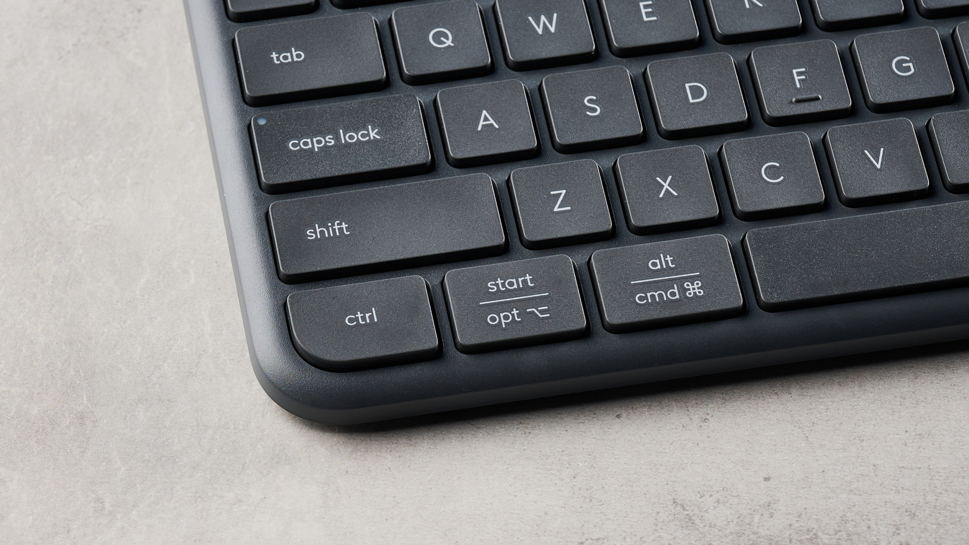 The Logitech K620 keyboard in a graphite grey colorway photographed as part of the MK625 como on able and white background.