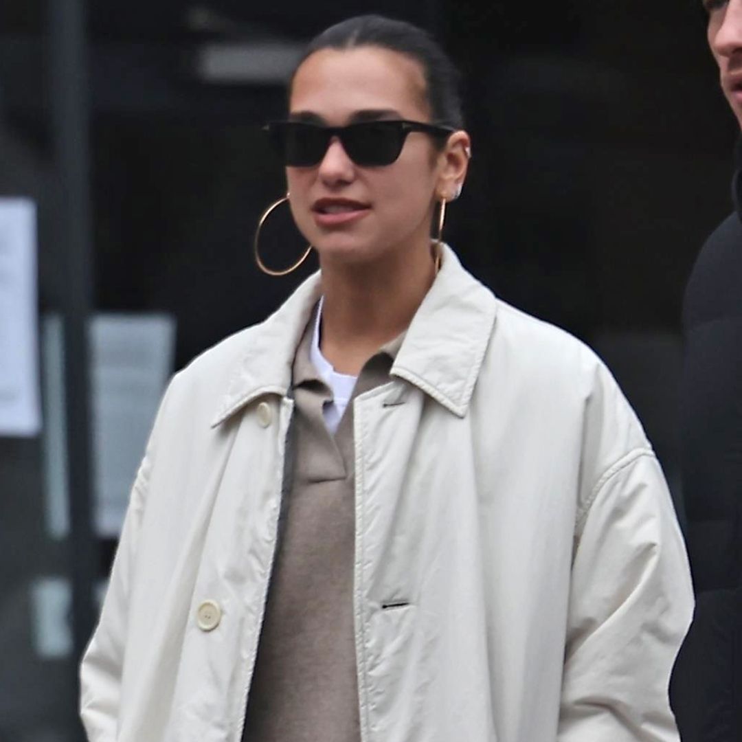 Dua Lipa was spotted in London wearing a khaki trench coat, a polo sweater, and statement Moon Boots