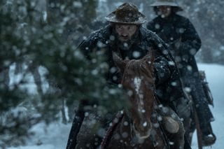 jai courtney as virgil cutter riding a horse in the snow in american primeval