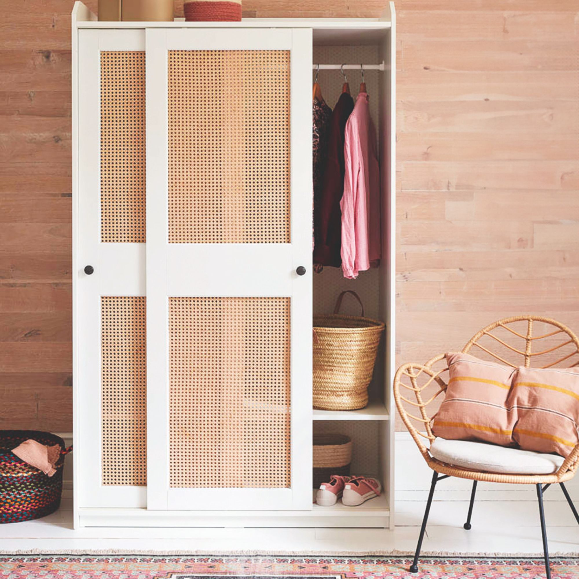 Wooden wardrobe with rattan doors, with a wicker accent chair in front