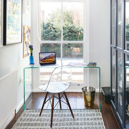 Glass desk in front of window