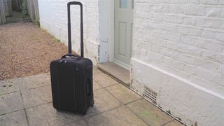 Tenba Roadie Air Case Roller 21 camera bag in front of a house