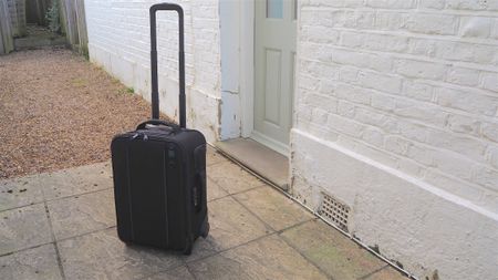 Tenba Roadie Air Case Roller 21 camera bag in front of a house