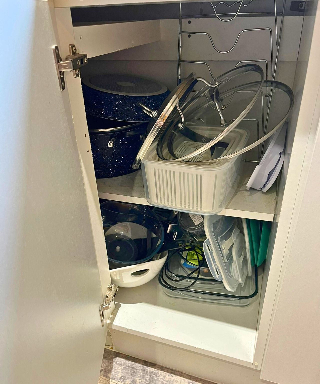 My pan lids stacked haphazardly in my open kitchen cabinet