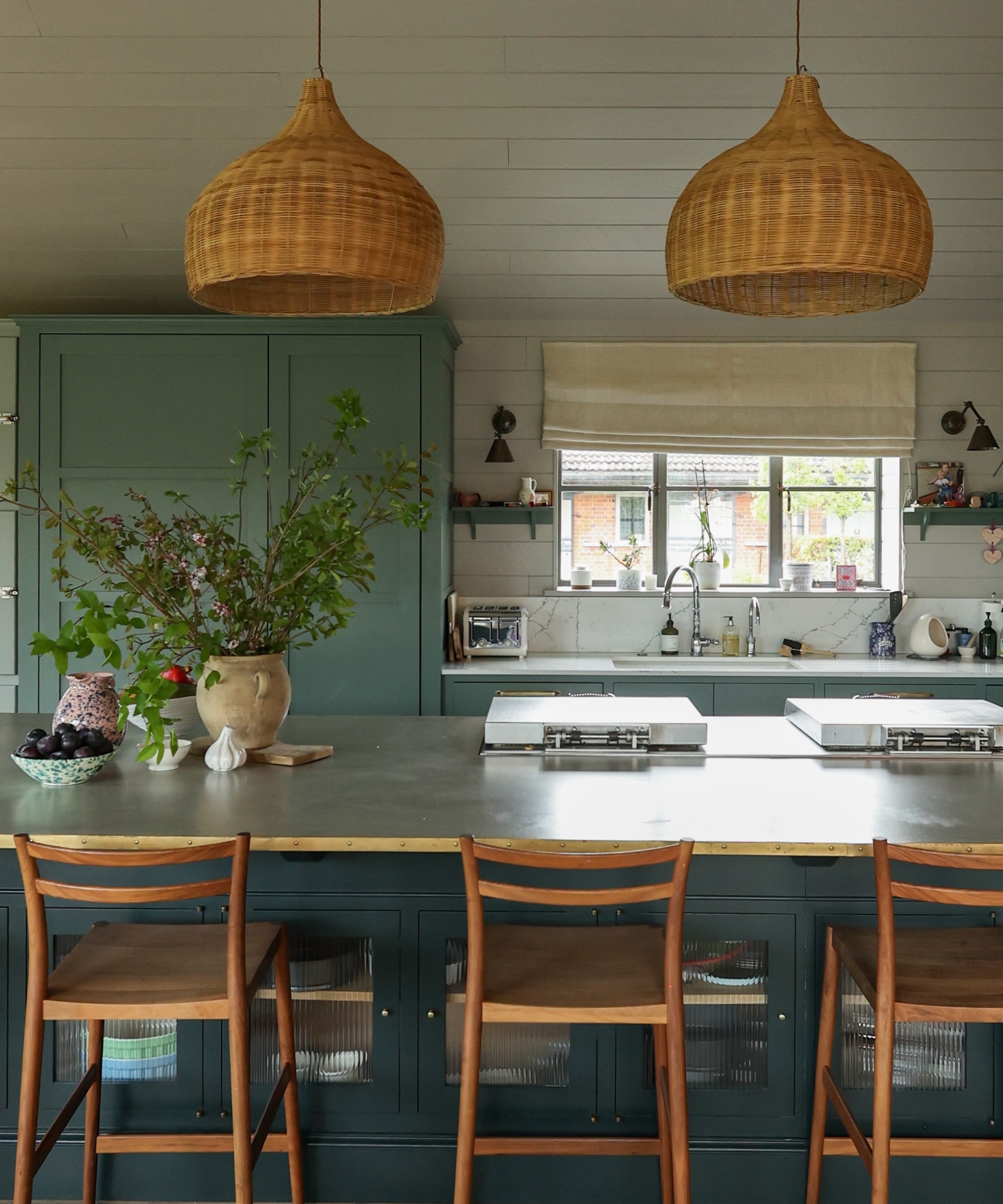 A moody kitchen with smoky blue-green cabinets and wood accents