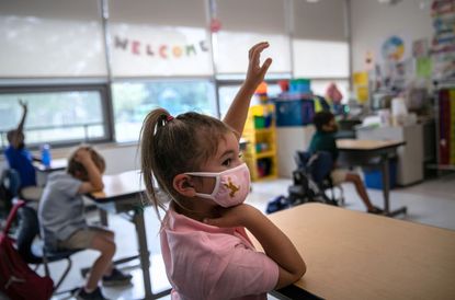 Harper Shea (5), raises her hand during her first day of kindergarten on September 9, 2020 in Stamford, Connecticut.