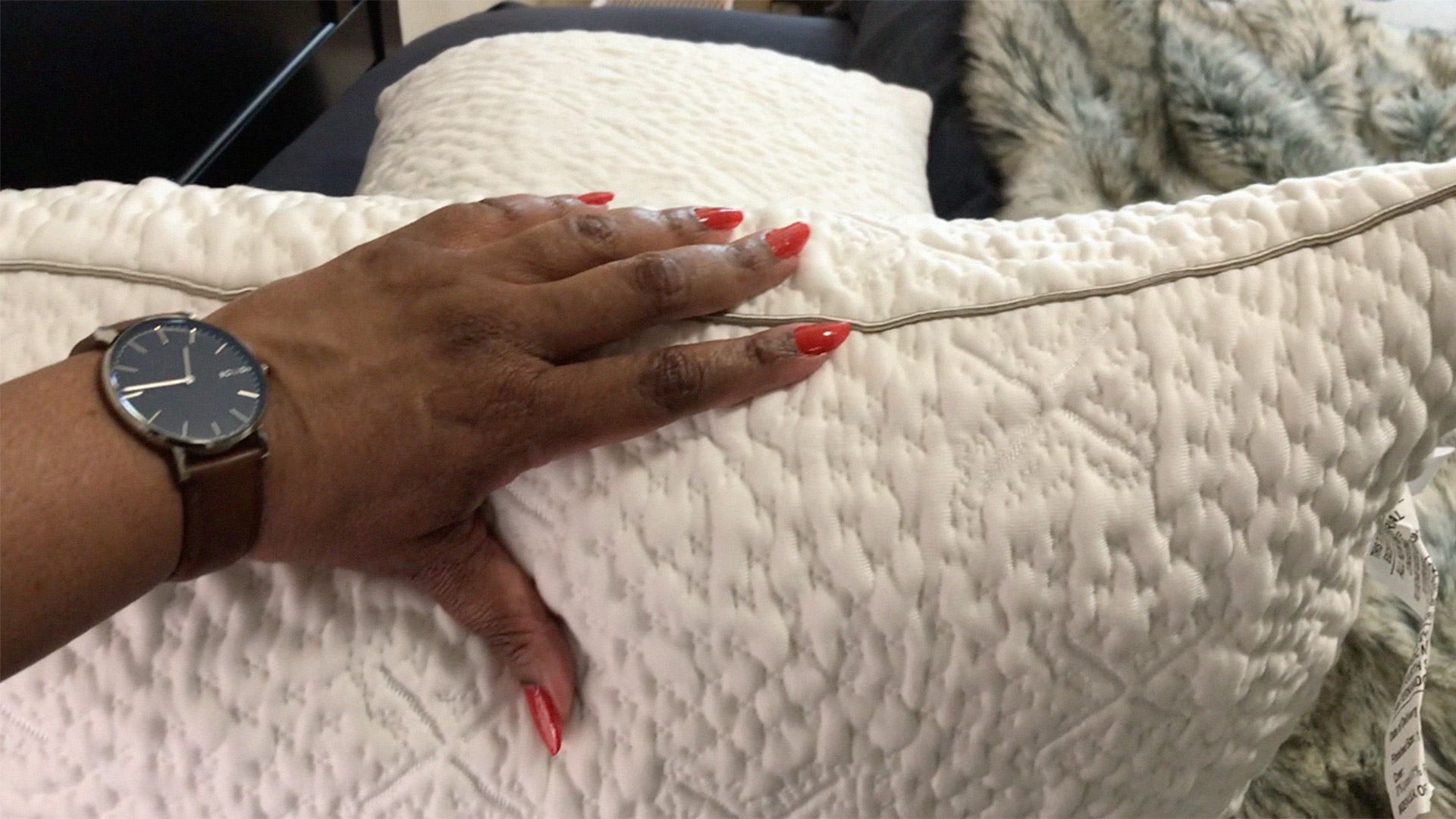 A hand on a Sleep Number ComfortFit Pillow