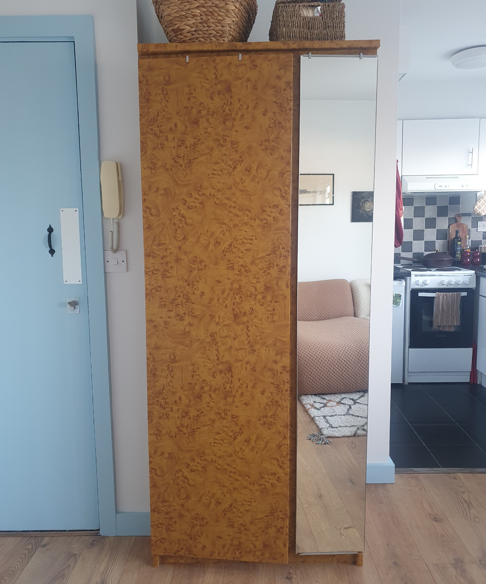 My closed wardrobe witha mirrored section and storage baskets baskets on top