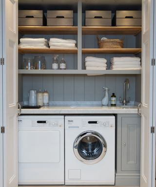 slatted wooden shelves above sink and washing machine in laundry room