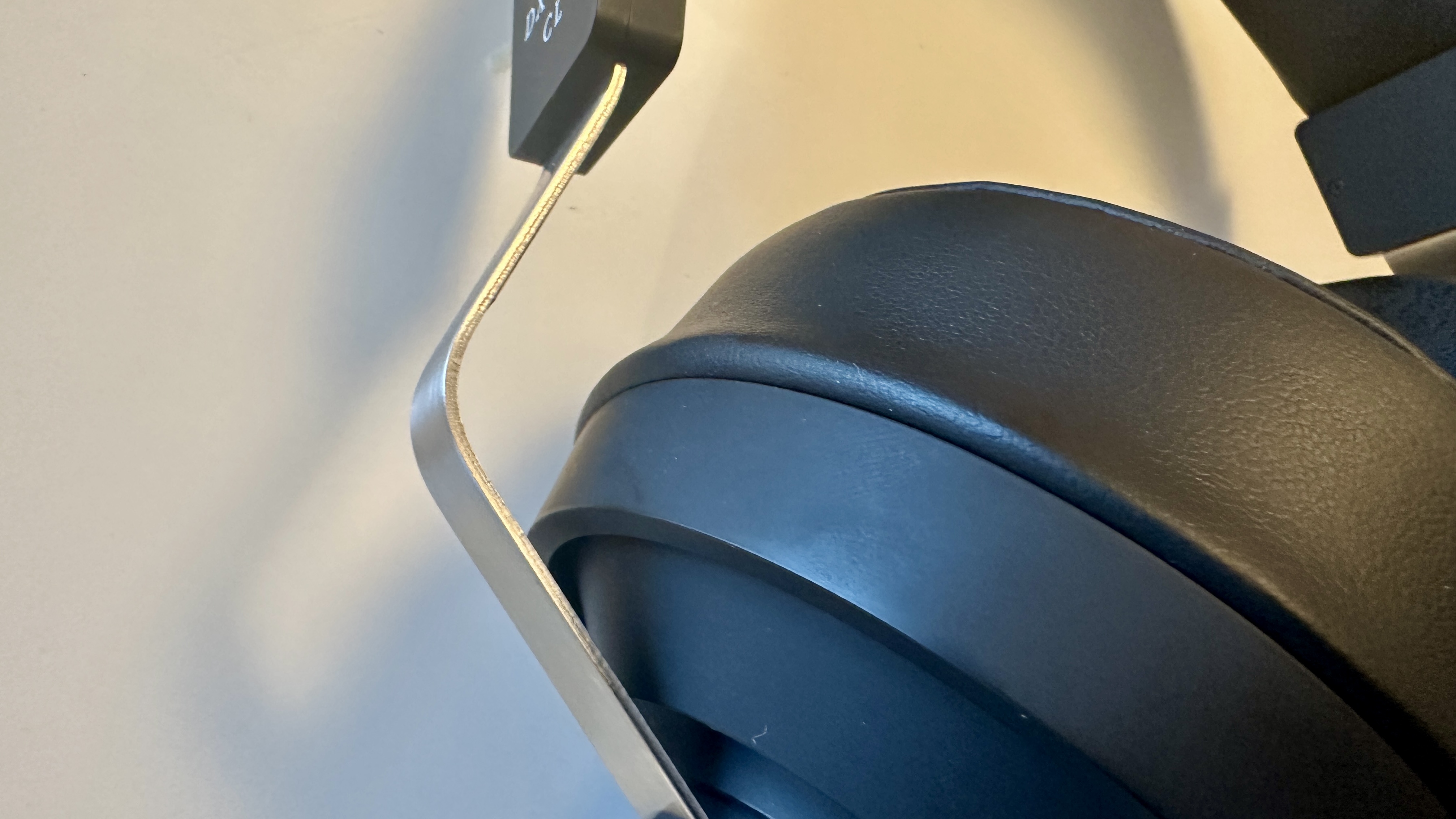 Close ups of the Final DX3000CL with a hi-res digital audio player, showing the ear cups, arm and screen on the player, all on beige background