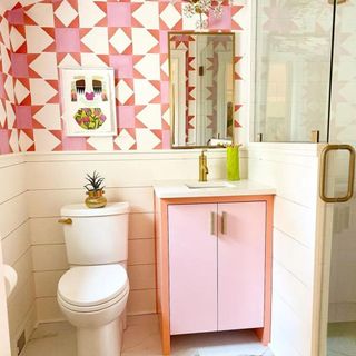 @emilymangusinteriors's pink bathroom with a pink vanity and white tiles and a standing shower