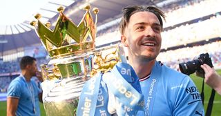 Jack Grealish of Manchester City celebrates with the Premier League trophy following the Premier League match between Manchester City and Chelsea FC at Etihad Stadium on May 21, 2023 in Manchester, England.
