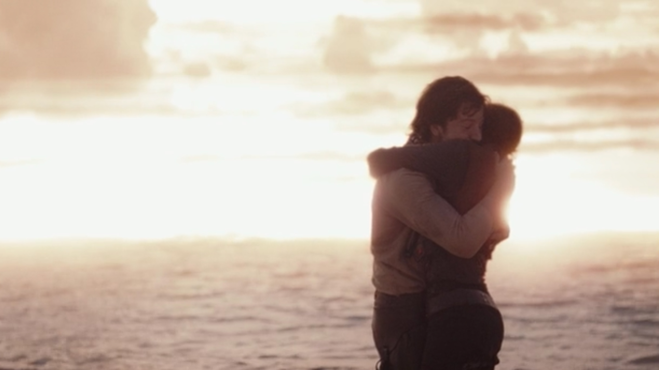 Cassian Andor and Jyn Erso embrace.