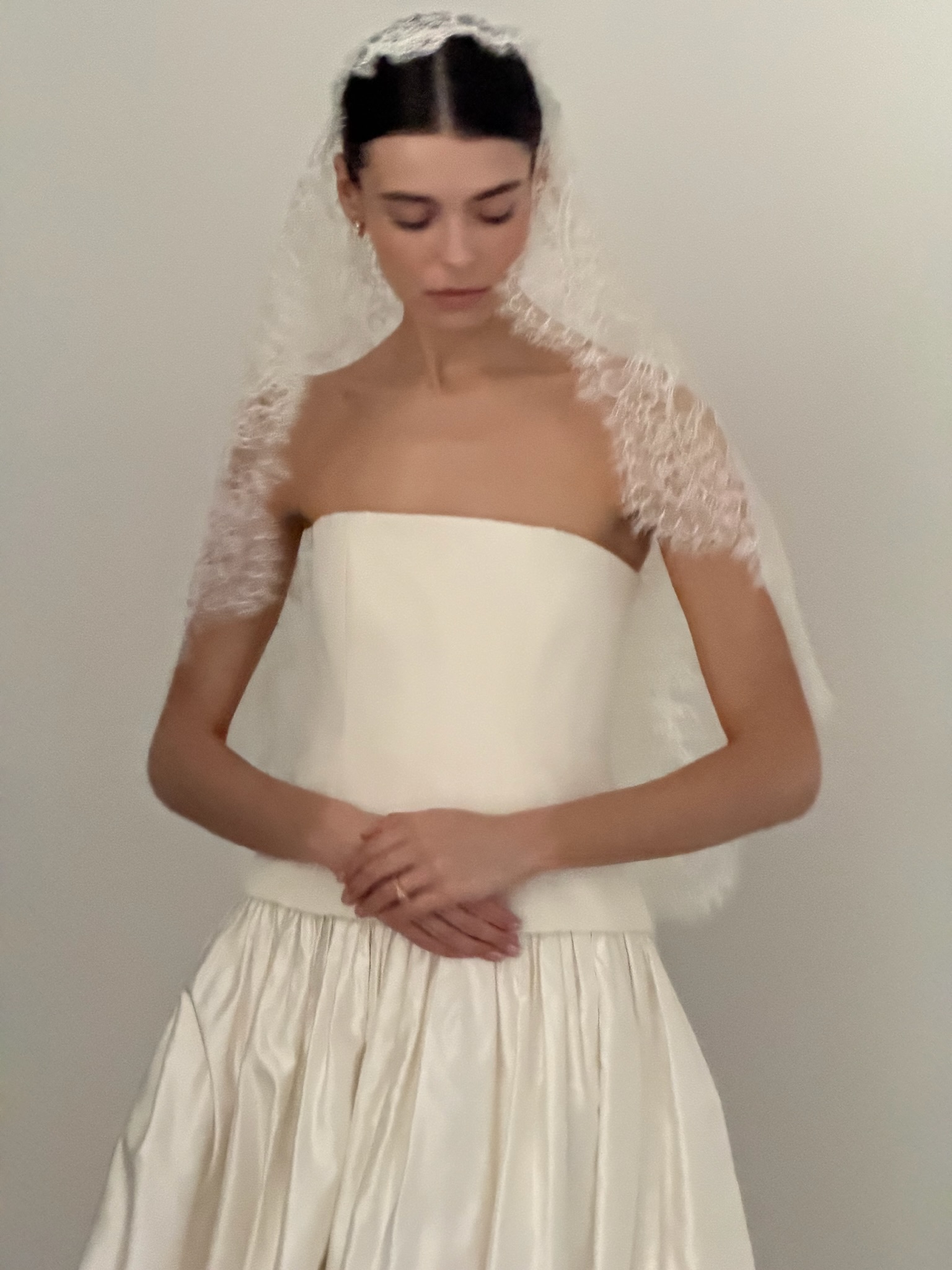 a model wearing a clover london wedding gown and lace veil